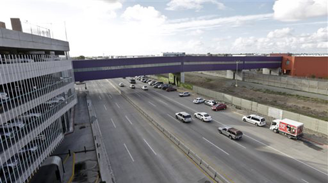 Vehicles pass under a walking bridge that connects the new Cross Border Xpress air terminal in San Diego, right, to the Tijuana International Airport, left. (Photo: AP) Vehicles pass under a walking bridge that connects the new Cross Border Xpress air terminal in San Diego, right, to the Tijuana International Airport, left. (Photo: AP)